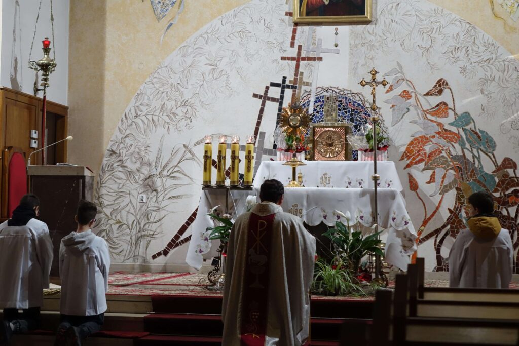 Kapłan klęczący przed ołtarzem głównym