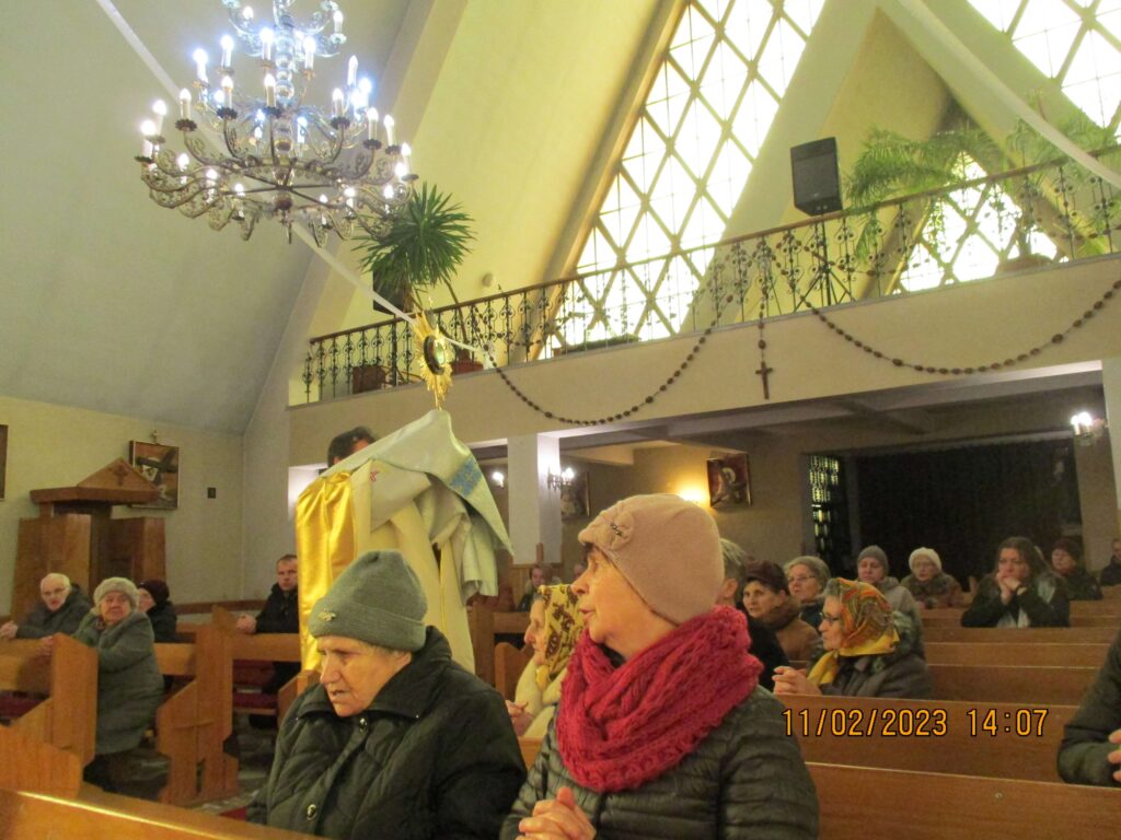 Kapłan błogosławiący parafian 