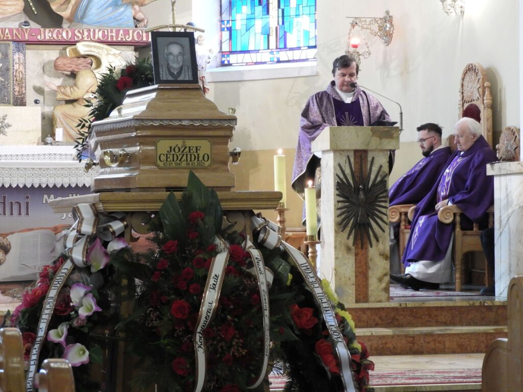 Ksiądz w kościele przy trumnie 