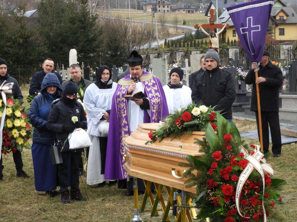 Ksiądz z parafianami na cmentarzu 